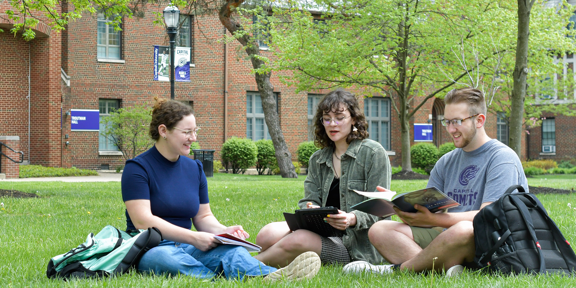 Students Sitting On Lawn In Quad