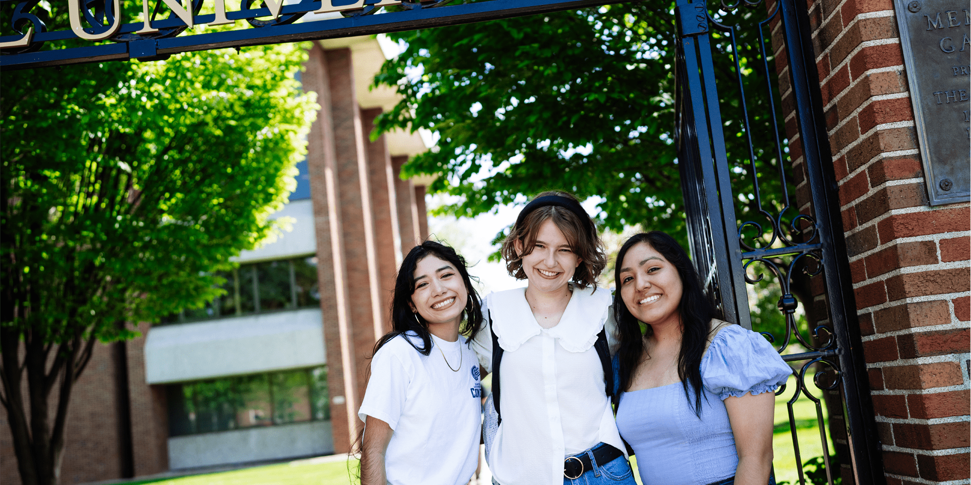 Students Posing In Front Of Gate Min