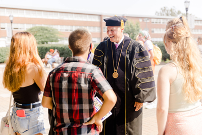 President Kaufman Laughing With A Group Of Students