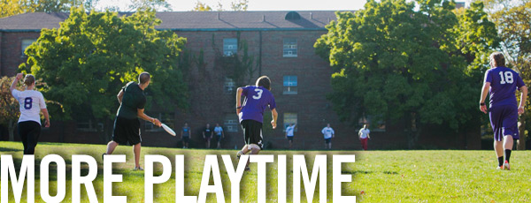 college students playing frisbee in a field