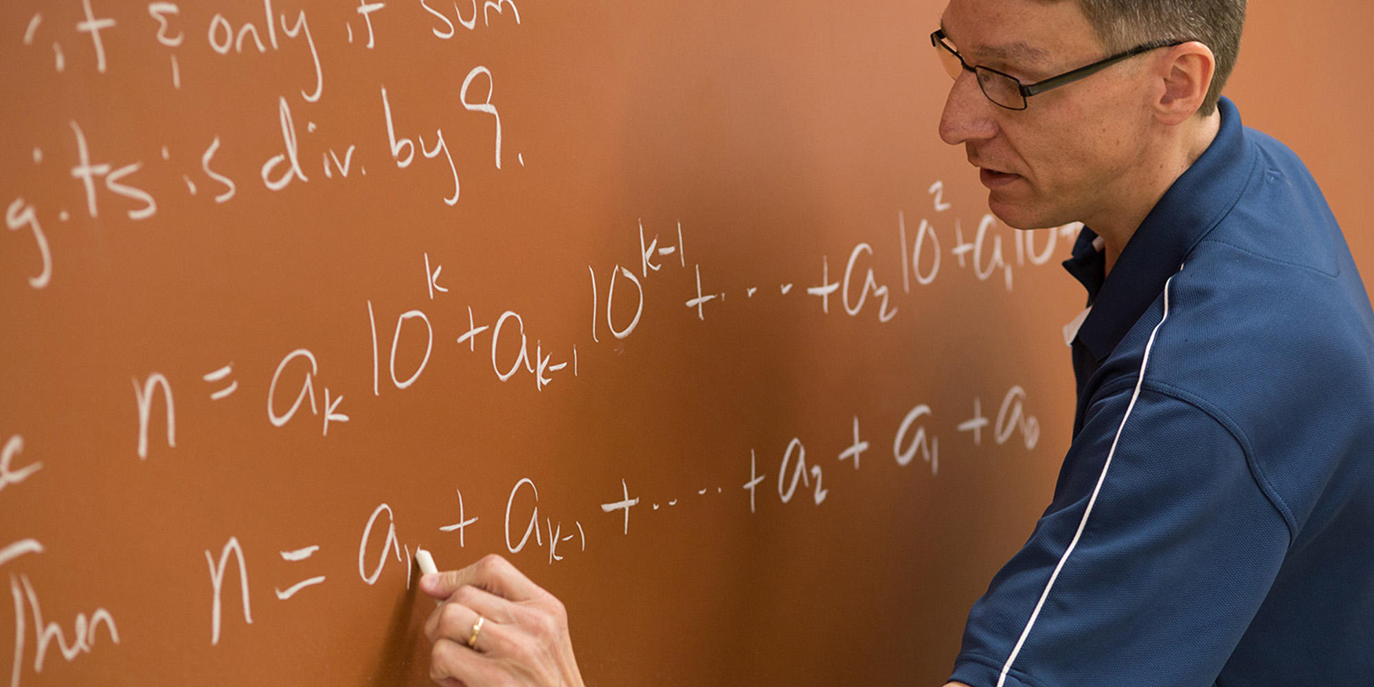 Math Professor Writing Equation On A Chalkboard
