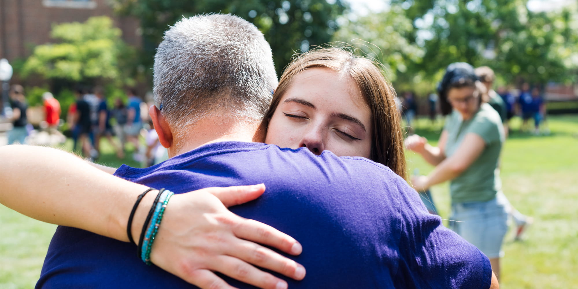A student hugs her family member