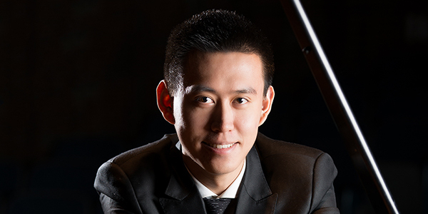 Young man Wenting Yu in black suit and tie smiling
